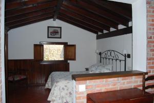 sypialnia z łóżkiem i oknem w obiekcie Apartamentos El Perujo w mieście Comillas