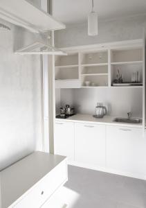 uma cozinha branca com armários brancos e um lavatório em Smart Central Apartments em Milão