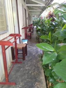 a corridor with red tables and chairs and plants at Moonriver Lodge in Cameron Highlands