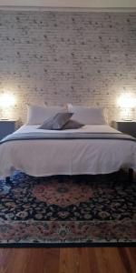 una camera da letto con un grande letto bianco con un muro di mattoni di Antico Affittacamere di Tollegno a Tollegno