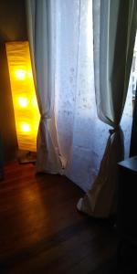 ventana con cortina blanca en el suelo de madera en Antico Affittacamere di Tollegno, en Tollegno