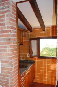 łazienka z pomarańczowymi kafelkami i ceglaną ścianą w obiekcie Apartamentos El Perujo w mieście Comillas +19 zdjęć