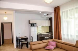 a living room with a couch and a kitchen at VELVET RESIDENCE in Mamaia Sat/Năvodari