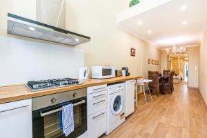 een keuken met een fornuis, een wasmachine en een droger bij Belem Skinny House in Lissabon