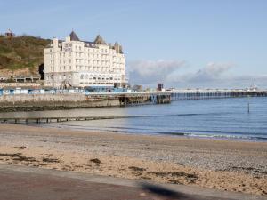 a building on the beach next to a pier at 10 The Orchard in Colwyn Bay