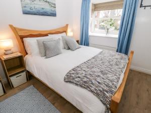 a bedroom with a large bed and a window at 10 The Orchard in Colwyn Bay