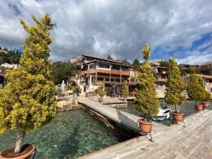 una casa en el agua con árboles delante de ella en Sahil Pension, en Kaleucagız