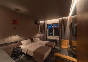 a hotel room with two beds and a television at Дизайн-готель ROAD in Kyiv