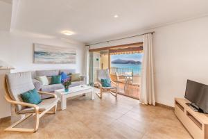 - un salon avec un canapé et une télévision dans l'établissement Apartamento Buganvilia sea, à Alcúdia