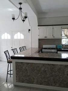 a kitchen with a large counter with chairs in it at Candy Haven in Morne Jaloux Ridge