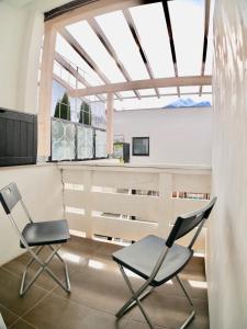 2 sillas y una mesa en una habitación con ventana en Suite Mutters, en Innsbruck
