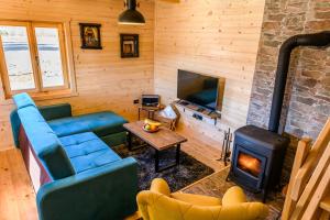 Happy2cu Cabin في كولاسين: غرفة معيشة مع أريكة ومدفأة