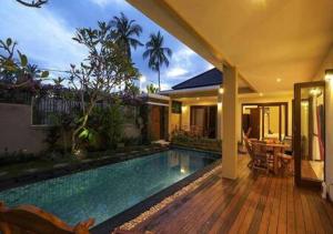 a swimming pool in a villa with a house at Villa Mantika in Senggigi 
