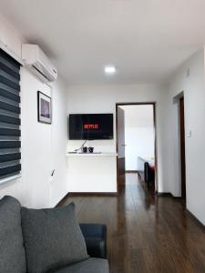 - un salon avec un canapé et une télévision murale dans l'établissement Modern Apartment, à Brčko