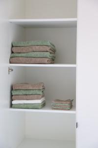 a stack of towels on a shelf in a bathroom at Maison Marie in Middelkerke