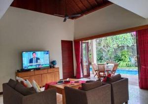 a living room with two couches and a television at Villa Mantika in Senggigi 