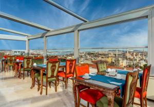 ein Esszimmer mit Tischen und Stühlen auf dem Balkon in der Unterkunft Hotel Sultanhan - Special Category in Istanbul