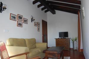 salon z kanapą i telewizorem w obiekcie Apartamentos El Perujo w mieście Comillas