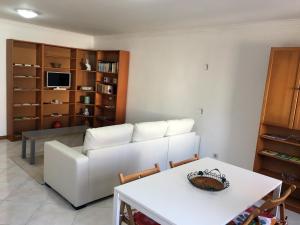 uma sala de estar com um sofá branco e uma mesa em Casa da Gramática em Viana do Castelo