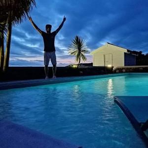 a man standing on the edge of a swimming pool at GRANARY'S HOUSE in Sete Cidades