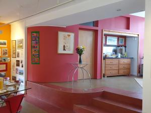 una habitación con una pared roja y una mesa con flores. en The Dyehouse, en Waterford