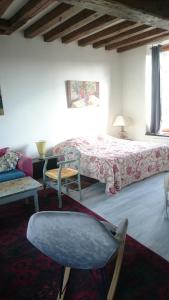 ein Schlafzimmer mit einem Bett, einem Stuhl und einem Sofa in der Unterkunft Rémalard appartement in Rémalard
