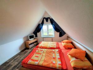 una camera mansardata con due letti e una finestra di Pension Gästehaus Elfriede Baltrum a Baltrum