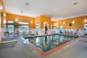 a large swimming pool with chairs and tables in a building at La Quinta by Wyndham Houston Channelview in Houston