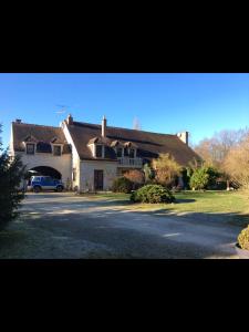 une grande maison avec une voiture garée devant elle dans l'établissement la VILLA B Chantilly, à Orry-la-Ville