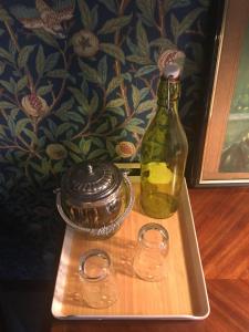 une bouteille de vinaigre et deux verres sur un plateau dans l'établissement la VILLA B Chantilly, à Orry-la-Ville