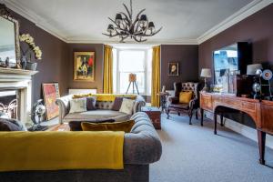 a living room with a couch and a fireplace at The Surveyor's House Tetbury in Tetbury