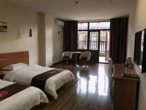 a hotel room with two beds and a desk at Thank Inn Chain Hotel hubei enshi railway station in Enshi