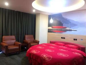 1 Schlafzimmer mit einem roten Bett und 2 Stühlen in der Unterkunft Thank Inn Chain Hotel hebei cangzhou botou city anshun street in Cangzhou