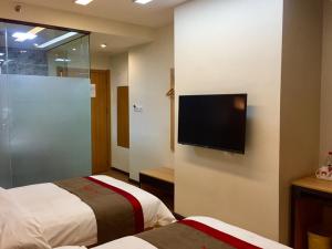 a hotel room with two beds and a flat screen tv at Thank Inn Chain Hotel fujian quanzhou fengze district donghai street in Quanzhou
