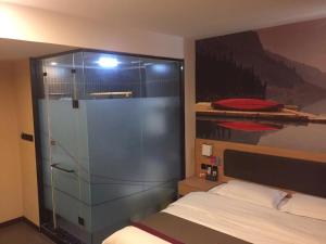 Schlafzimmer mit Glasdusche und Bett in der Unterkunft Thank Inn Chain Hotel hebei cangzhou botou city anshun street in Cangzhou