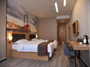 a hotel room with a large bed and a desk at Thank Inn Chain Hotel henan zhengzhou future road convention and exhibition center in Zhengzhou