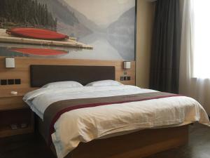 1 dormitorio con 1 cama grande y una pintura en la pared en Thank Inn Chain Hotel Shanghai baoshan district Yang Hang town, en Baoshan