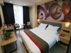 ein Hotelzimmer mit einem großen Bett und einem Schreibtisch in der Unterkunft Thank Inn Chain Hotel gansu jiuquan suzhou district bell and drum tower in Jiuquan