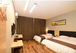 a hotel room with two beds and a television at Thank Inn Chain Hotel henan luoyang high-tech district jiudu west road zhoushan station in Luoyang