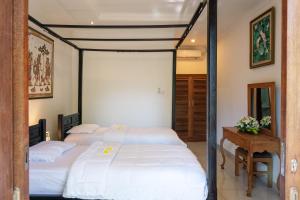 Postel nebo postele na pokoji v ubytování Batik Sekar Bali Guest House