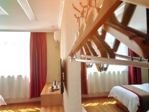Kaika的住宿－尚客优酒店西藏日喀则昂仁县县政府店，一间卧室设有楼梯,床配有红色窗帘
