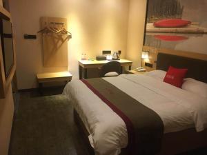 Habitación de hotel con cama y escritorio en Thank Inn Chain Hotel sichuan guang'an yuechi rongxinyue city en Guang'an