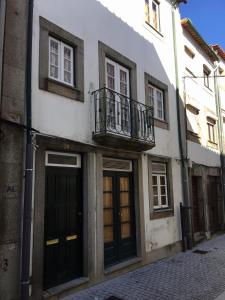 ein Gebäude mit Balkon und Türen auf einer Straße in der Unterkunft Casa da Gramática in Viana do Castelo