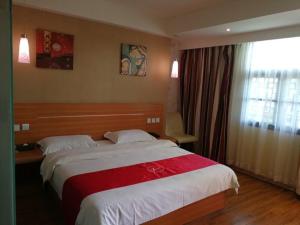 um quarto com uma cama grande e uma janela em Thank Inn Chain Hotel guizhou anshun huangguoshu scenic area em Anshun