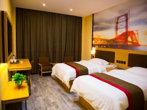a hotel room with two beds and a desk at Thank Inn Chain Hotel gansu tianshui maiji district xihuang avenue in Tianshui