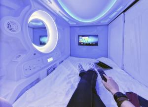 a person laying on a bed in an airplane at Capsule Hostels Tallinn in Tallinn