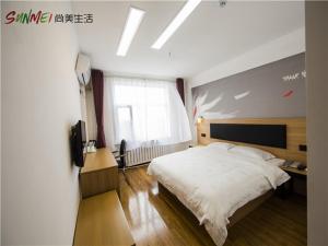 um quarto com uma grande cama branca e uma janela em Thank Inn Chain Hotel shandong yantai zhifu district RT-Mart railway station em Yantai