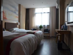 a hotel room with two beds and a window at Thank Inn Chain Hotel henan luoyang mengjin county huimeng avenue bilingual school in Luoyang