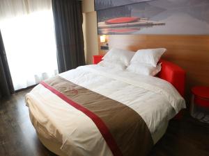 Schlafzimmer mit einem großen Bett mit einem roten Kopfteil in der Unterkunft Thank Inn Chain Hotel Jiangsu Yancheng Funing County Jinsha Lake in Yancheng