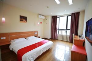 a hotel room with a bed and a flat screen tv at Thank Inn Chain Hotel hubei enshi railway station in Enshi